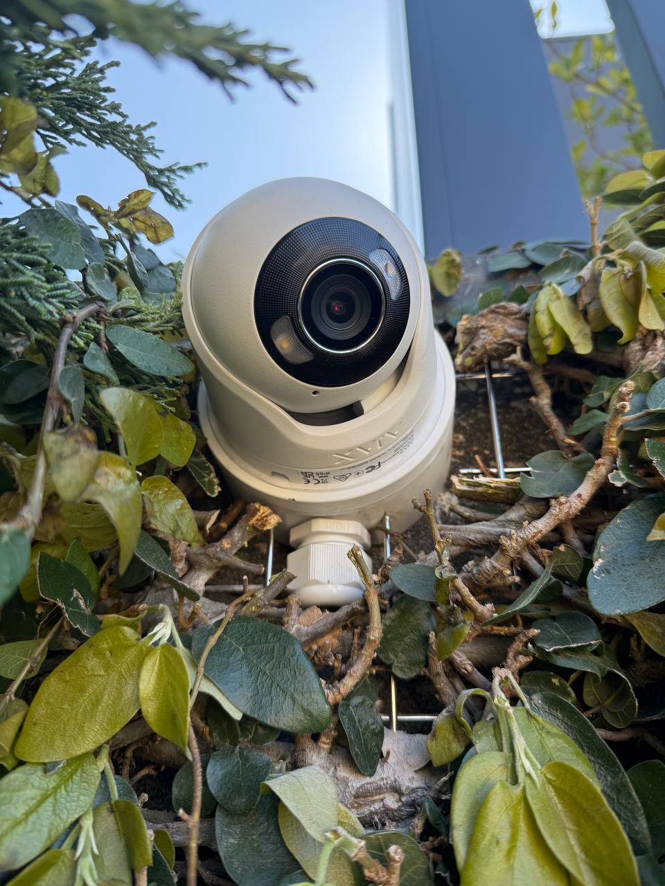 Compact AJAX security camera installed under an outdoor roof