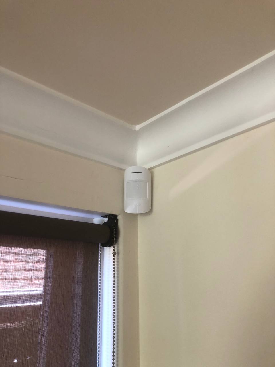 Indoor AJAX motion detector installed in a modern home