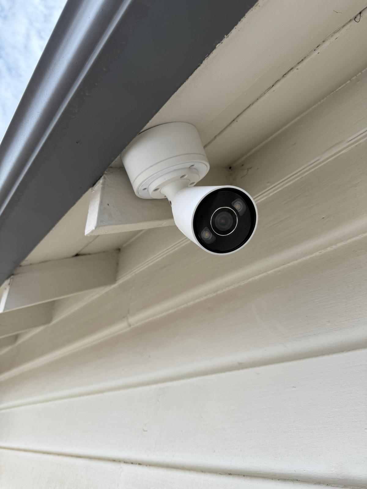 Compact AJAX security camera installed under an outdoor roof