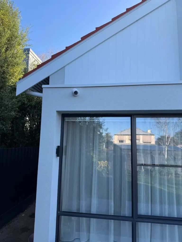 Dome security camera mounted on exterior wall above sliding glass door at a residential property in Armadale