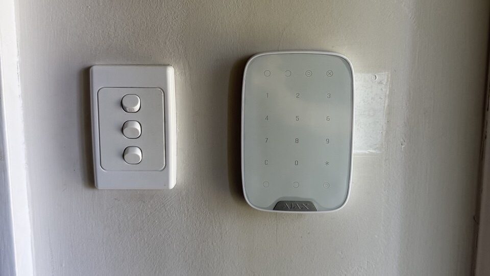 Ajax alarm keypad on interior wall - SIPKO Security Ajax alarm keypad installed on an interior wall beside a light switch