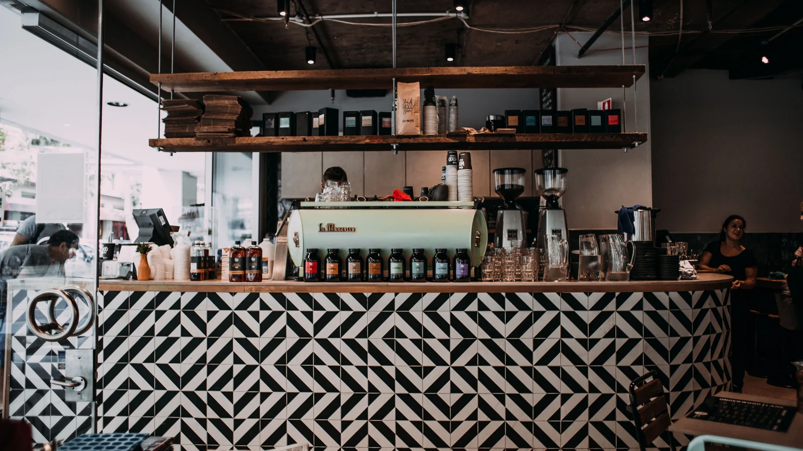 Café counter and till beside a bright glass entrance