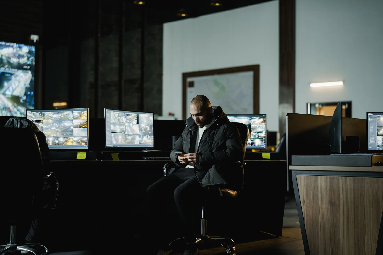 Seated operator in a control room with multiple CCTV surveillance monitors