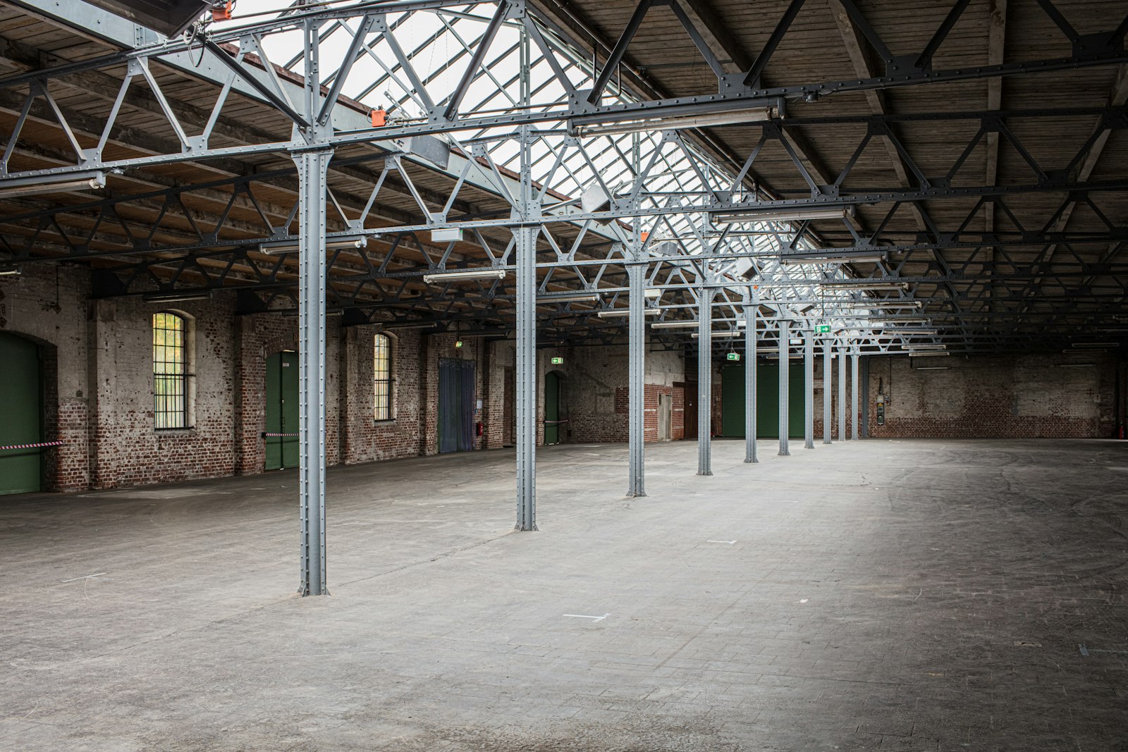 commercial-cctv-cost-melbourne-warehouse-ceiling - SIPKO Security Empty warehouse interior with high ceiling and steel roof trusses, the kind of site that needs a scissor lift for CCTV installation