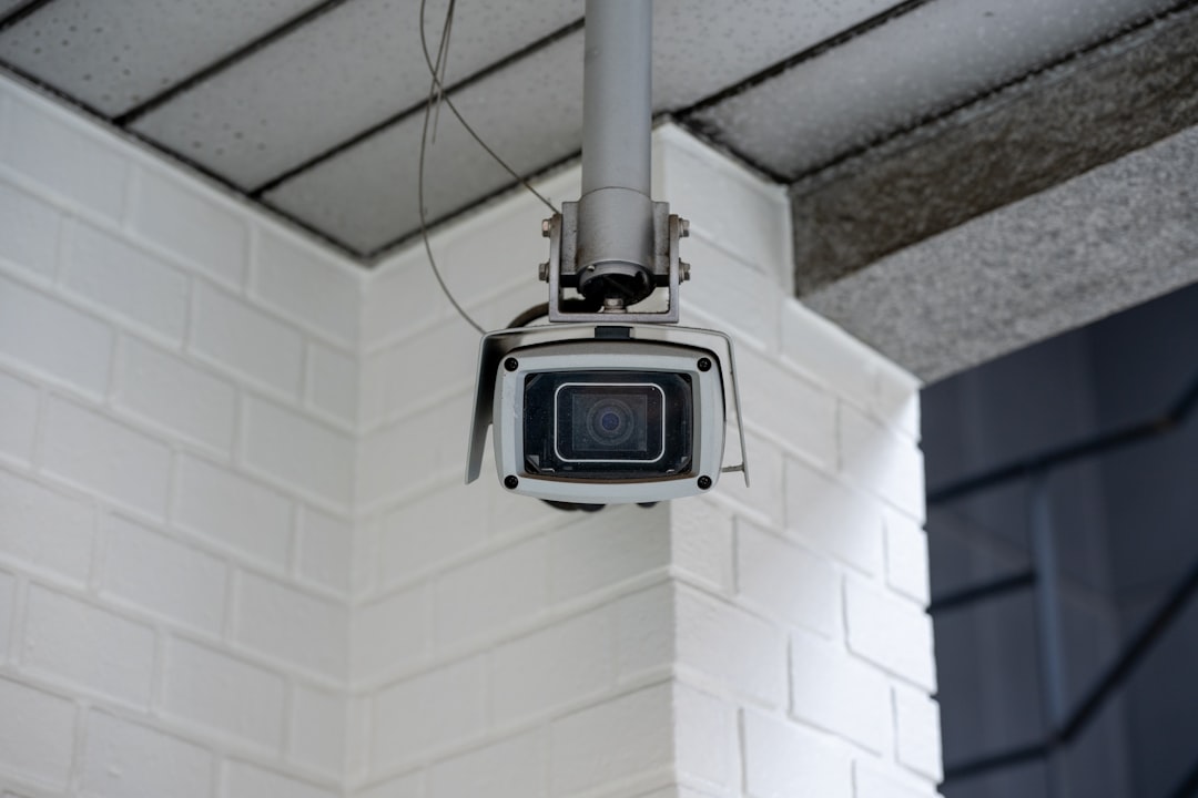 hardwired-poe-security-camera-homeowners-wall-mount - SIPKO Security White PoE security camera mounted on a brick wall, wired to a single Ethernet cable