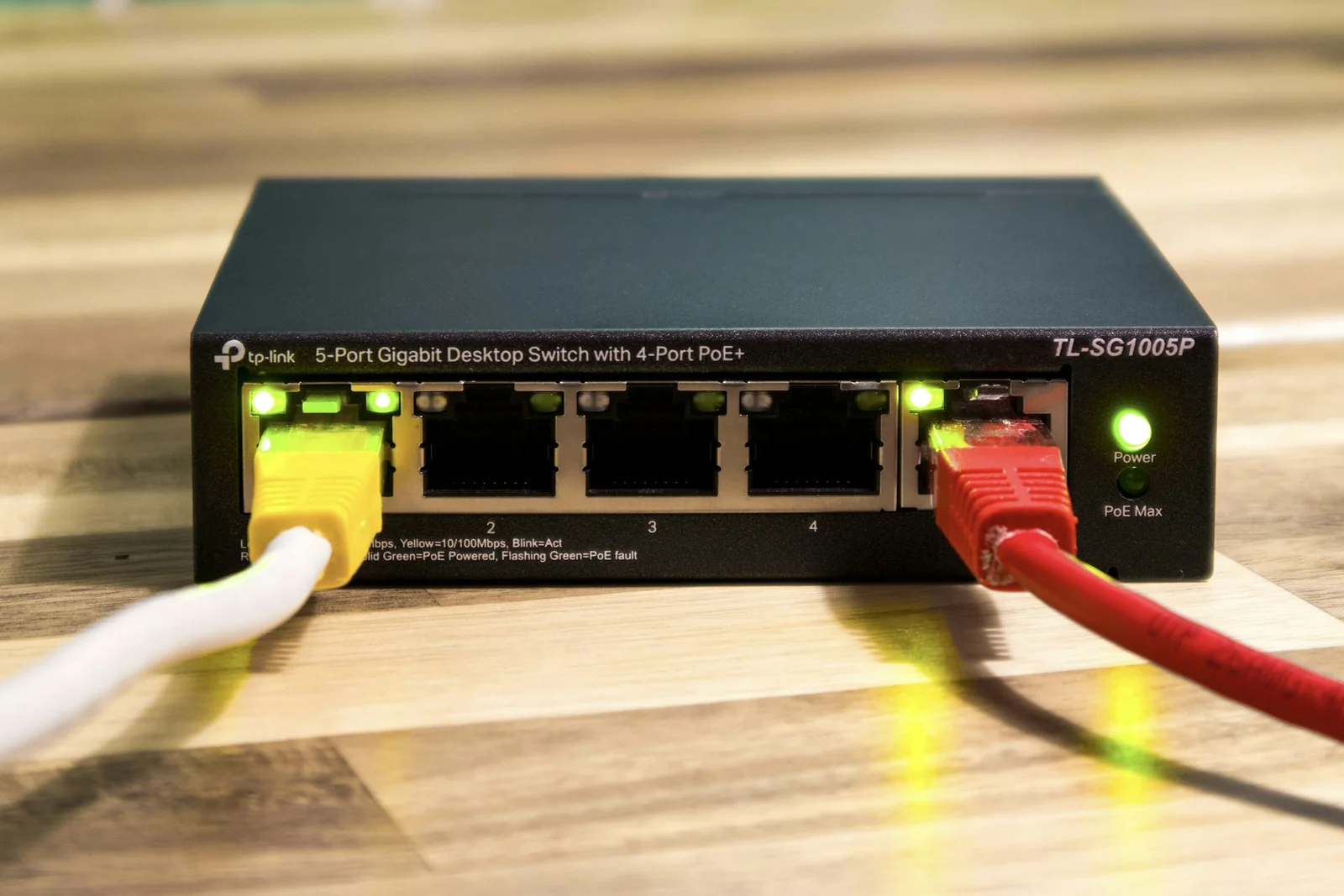 PoE network switch and Ethernet connections - SIPKO Security Ethernet cables connected to a five-port PoE network switch