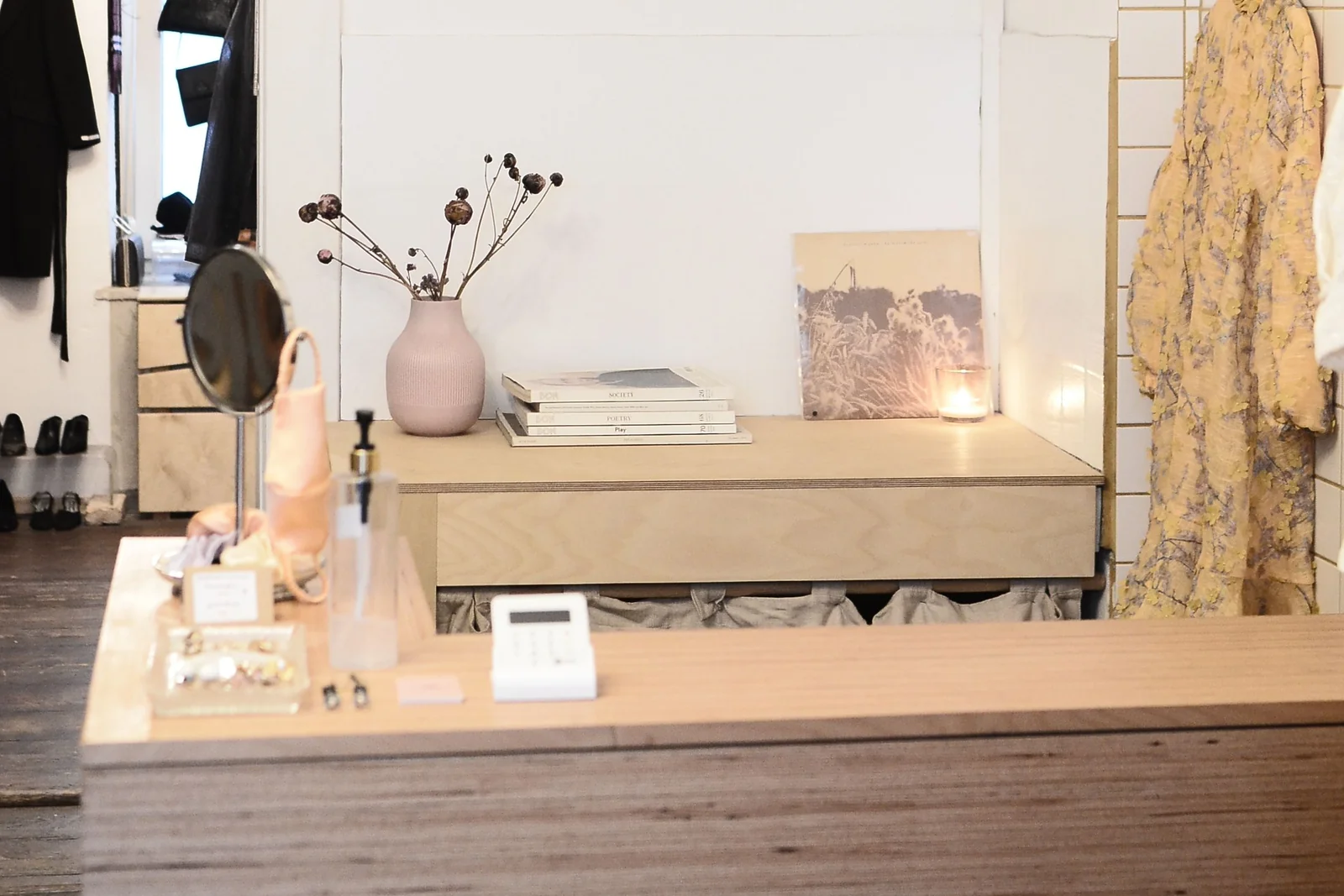 Small boutique shop counter and surrounding retail space - SIPKO Security Wooden boutique shop counter with a payment terminal and clothing displays