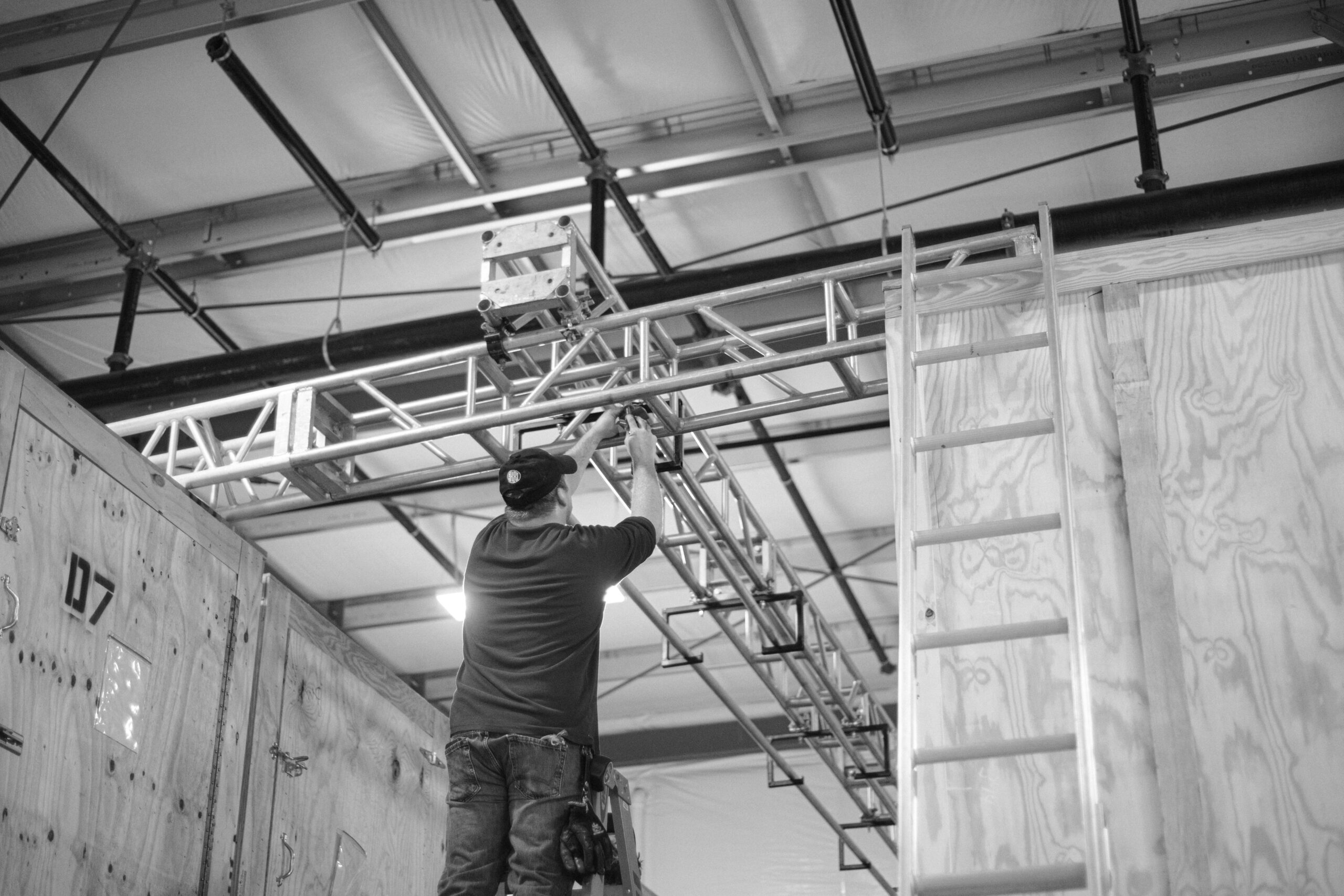Alarm panel retrofit wiring installation - SIPKO Security Tradesperson on a ladder working on wiring in a commercial ceiling space