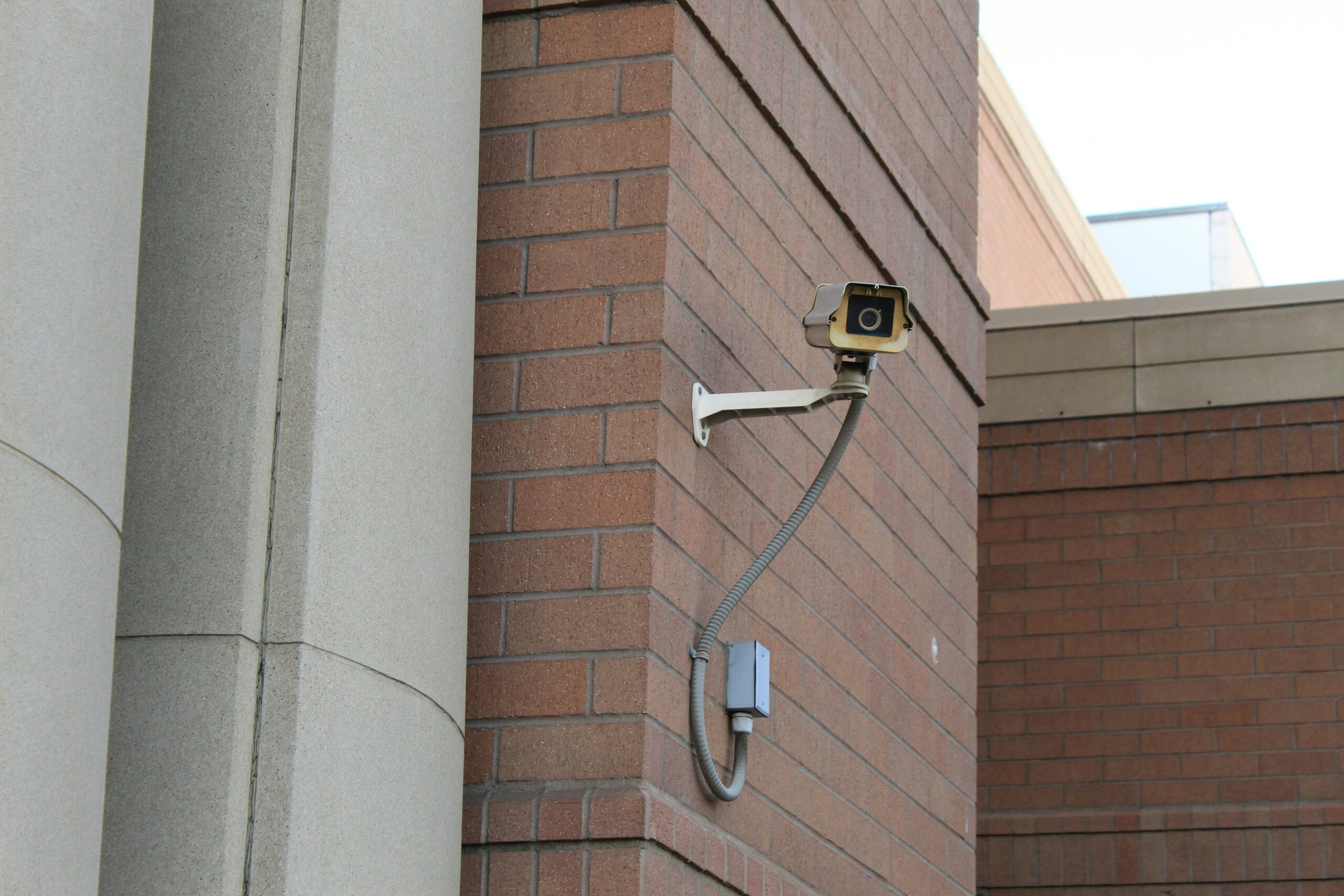 Security camera mounted on brick wall - SIPKO Security A security camera mounted on a red brick wall exterior
