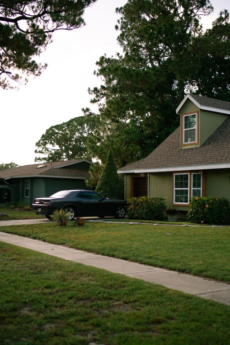 Car parked in a residential driveway beside a house - SIPKO Security Car parked in a residential driveway beside a house