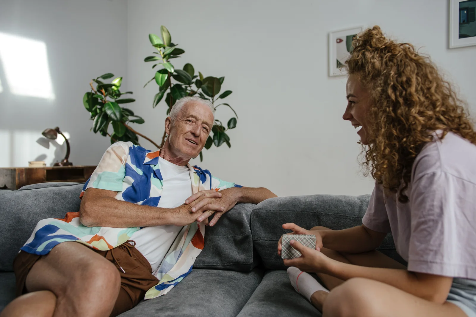 Family conversation about home security choices - SIPKO Security Older man and young woman talking together on a sofa at home