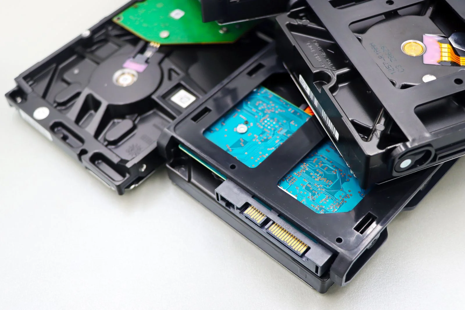 Stack of internal hard drives on a white surface - SIPKO Security Stack of internal hard drives on a white surface, a reminder that the drive and the recorder are separate parts