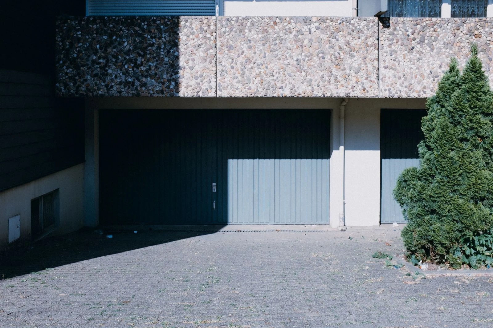 House exterior with two garage doors and a tree