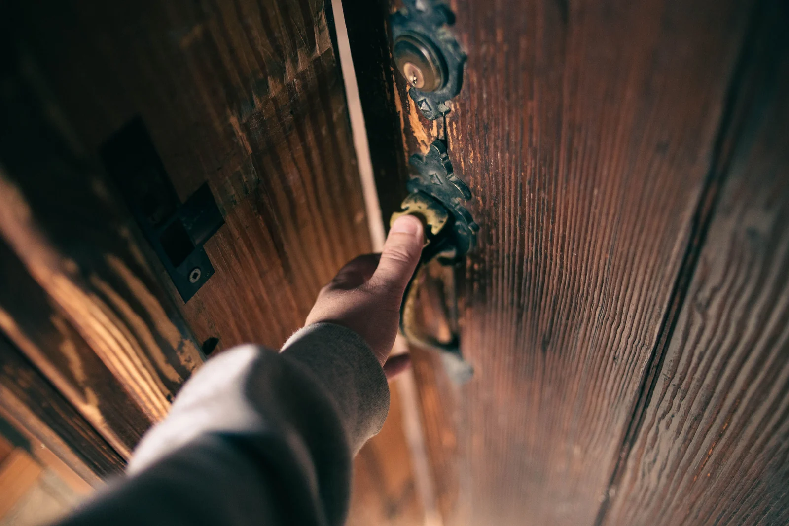 Hand pressing the handle of a wooden door, a door that has to close the same way every time for its sensor