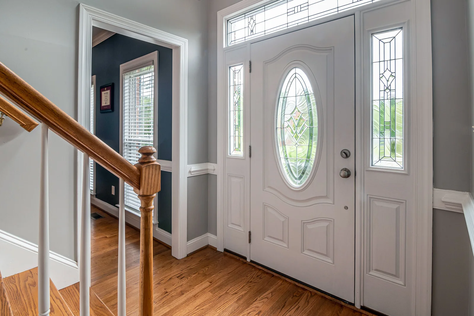 Home entrance and door security planning - SIPKO Security White front door with decorative glass panels beside an indoor staircase