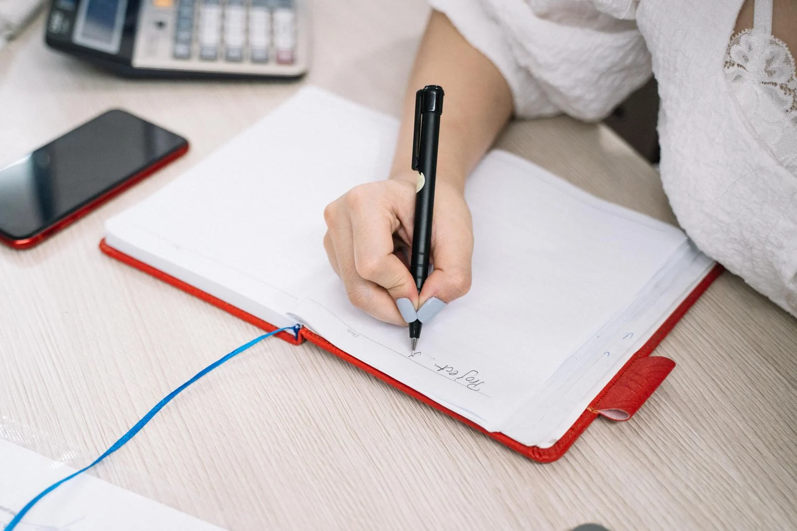 Mobile Data - supporting photo 2 - SIPKO Security Person writing notes beside a phone and calculator