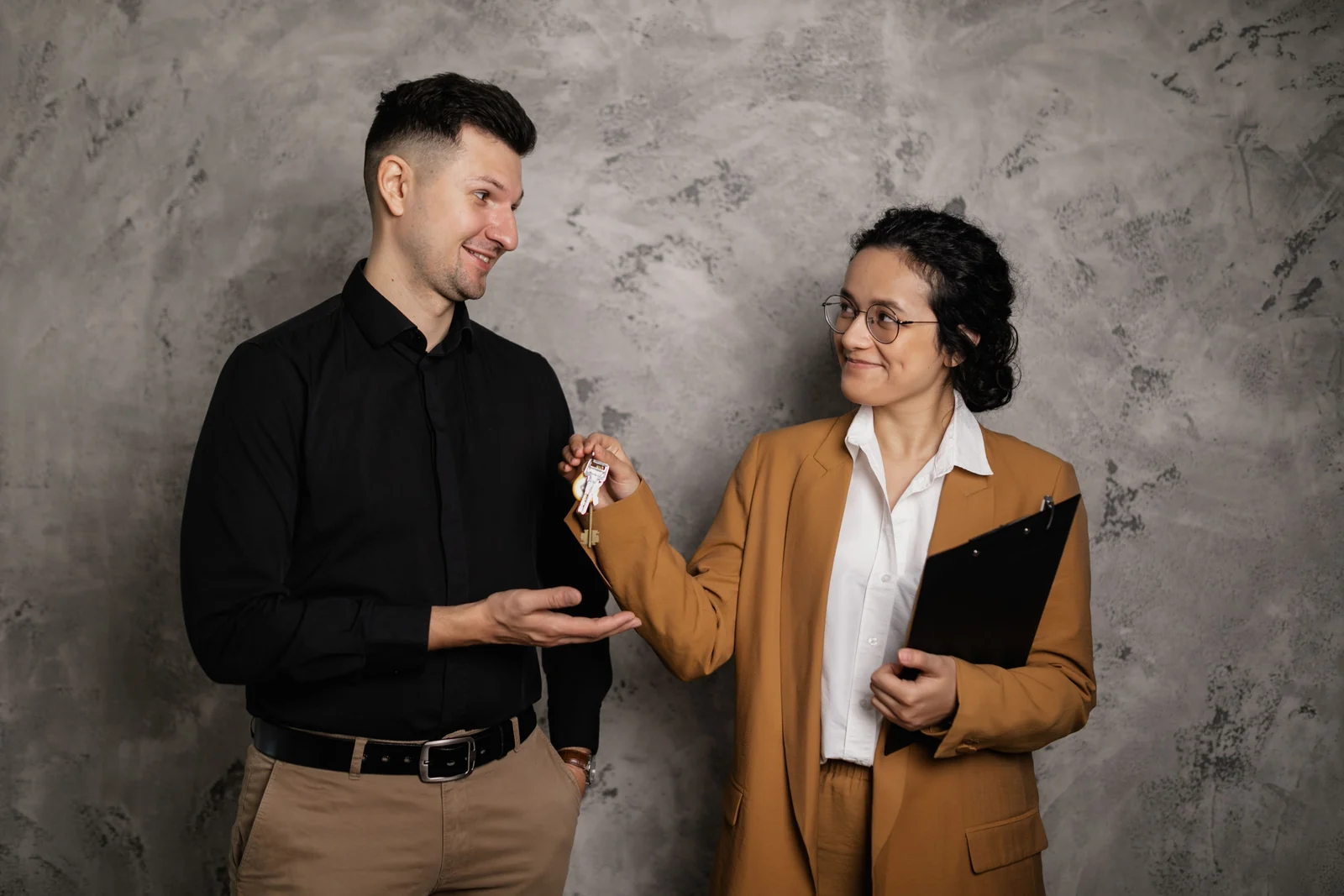 New homeowner receiving house keys - SIPKO Security Real estate agent handing house keys to a new homeowner indoors