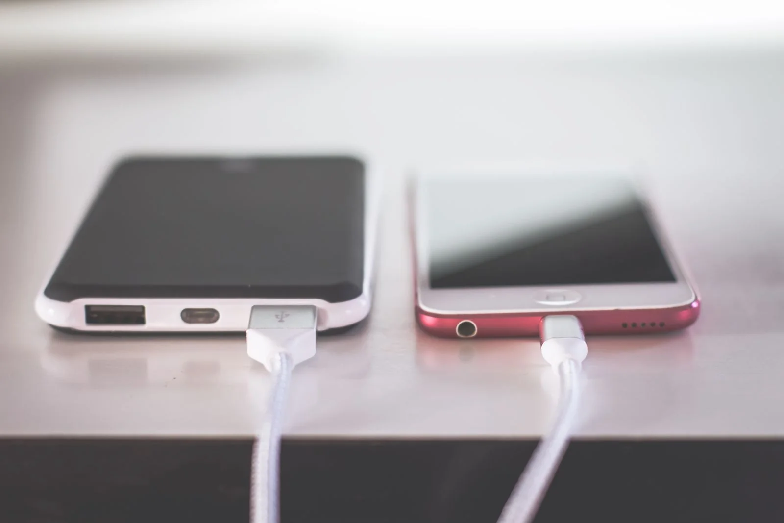 Two smartphones charging side by side on a desk - SIPKO Security Two smartphones charging side by side on a desk, the old phone kept beside the new one during the move