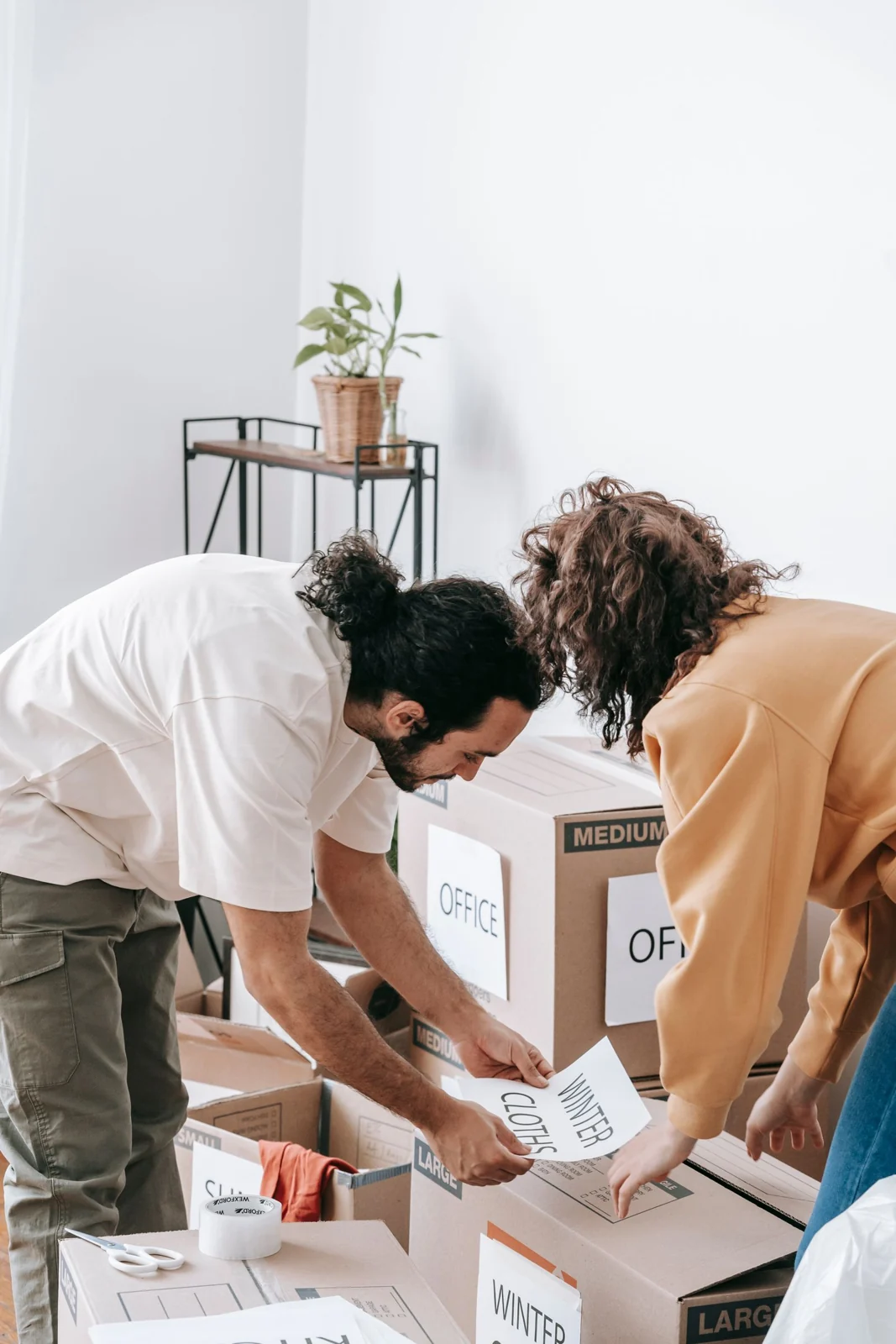 Renting guide - supporting photo 2 - SIPKO Security Couple labelling cardboard boxes while preparing to move