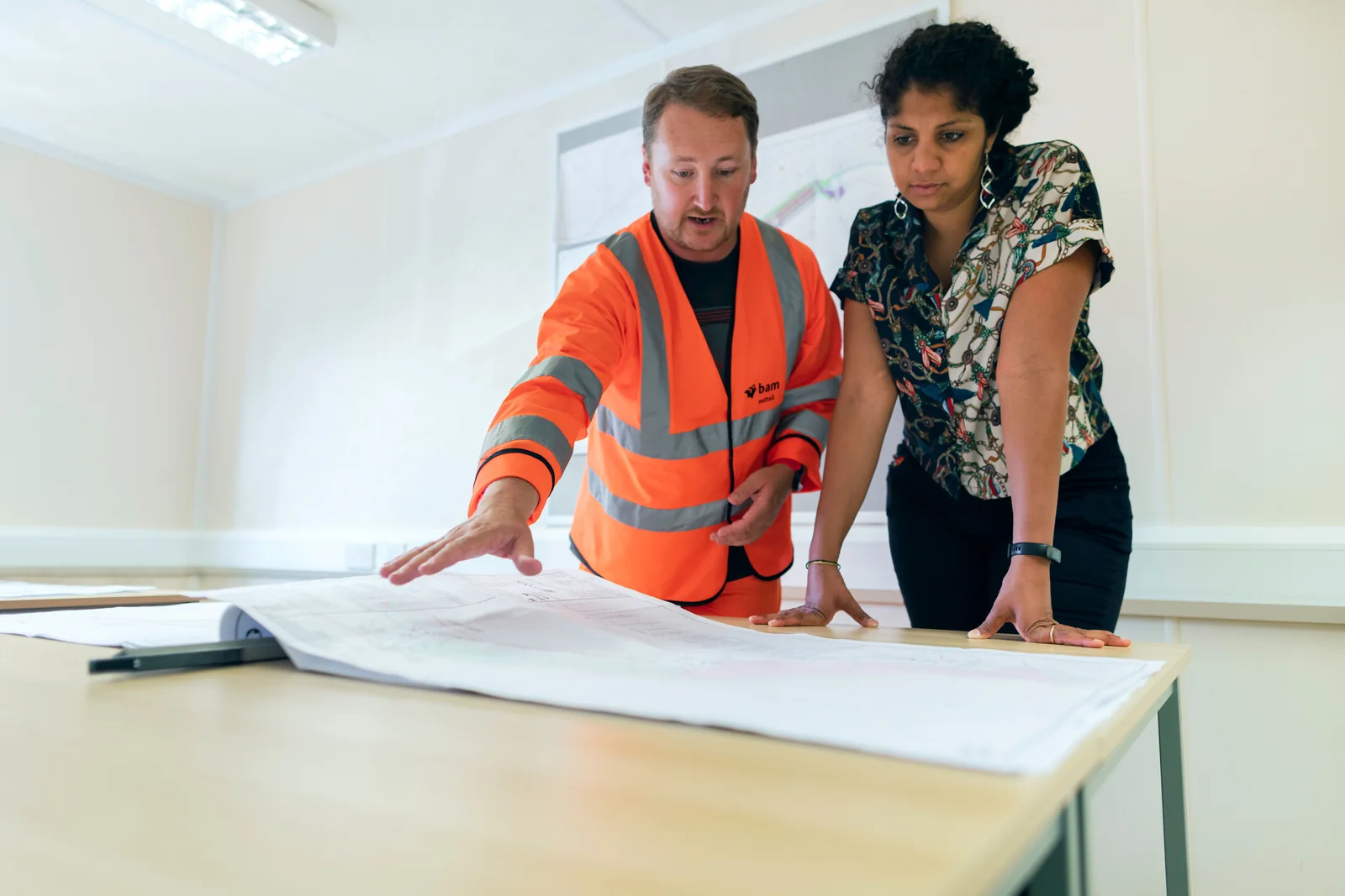 Two people reviewing building plans at a table