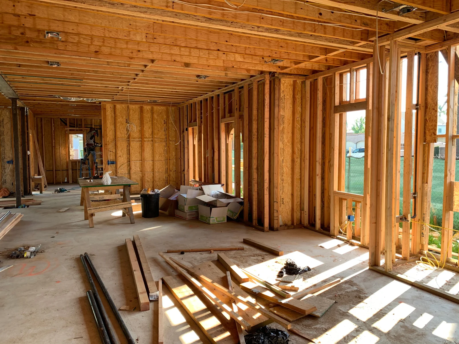 Interior of a house under construction with exposed timber framing and wiring
